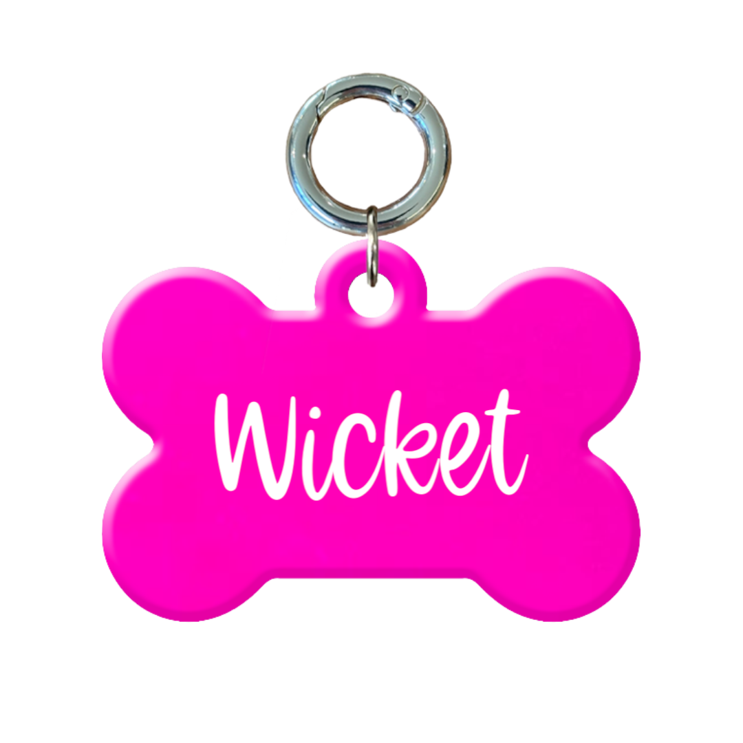 Fluro pink bone-shaped dog tag with metal ring, personalized with the name Wicket