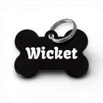 Black bone-shaped aluminium dog tag with dogs name  and phone number engraved.