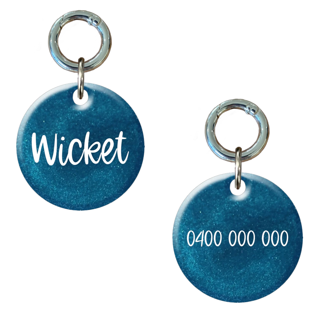 Blue round personalised dog tag with pet name and phone number engraving, metal ring attached