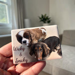 Magnet with two dogs' faces and names 'Wicky & Snicky' held in a hand.