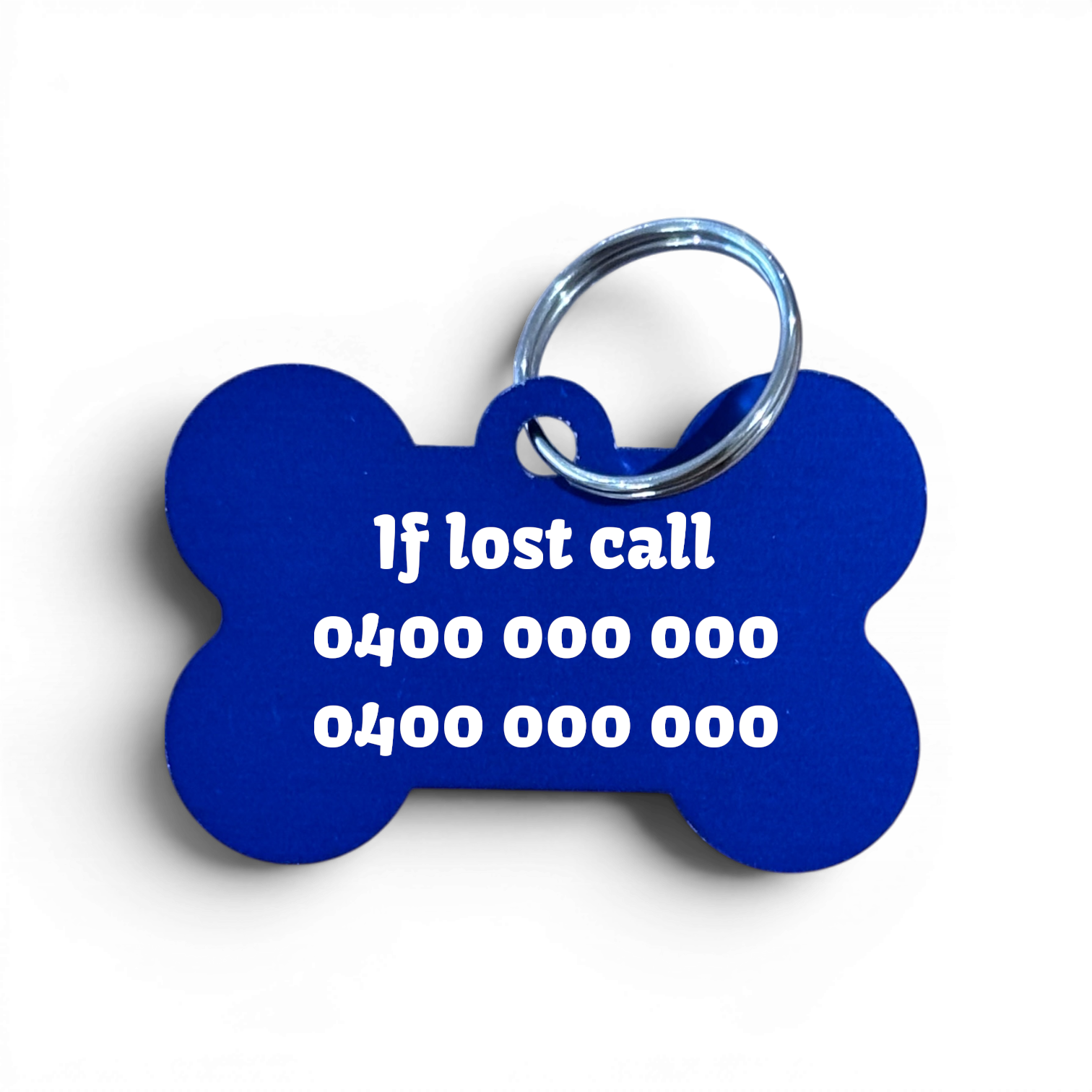 A bone-shaped blue pet ID tag with a silver metal key ring, featuring white printed emergency contact text on a white background.