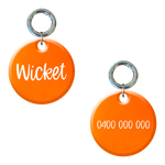 Fluoro orange round dog tag with 'Wicket' and a phone number, custom engraved, front and back view