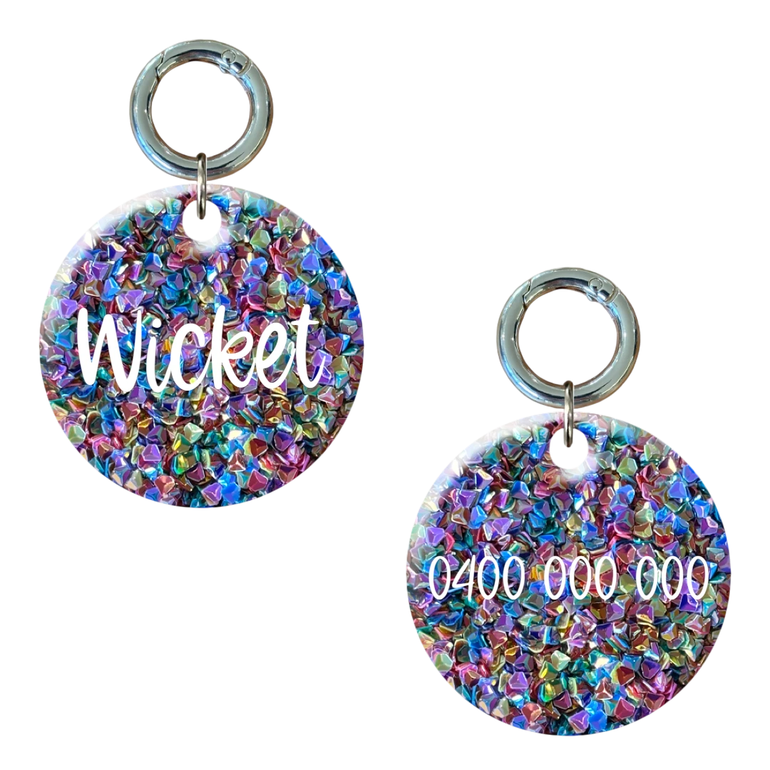 Round glittery dog tag with multicolored crystals, custom engraved with name and phone number.