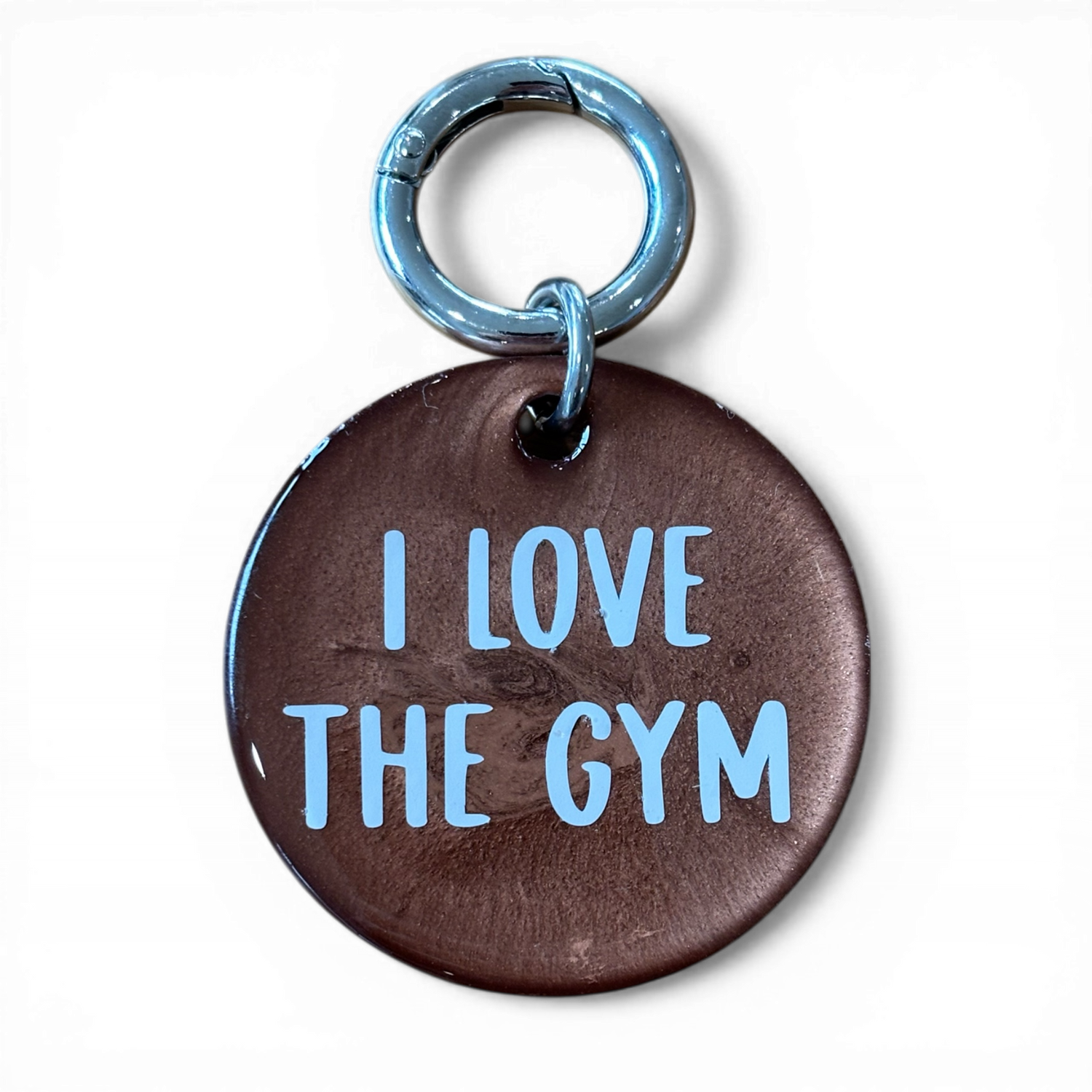 Brown round metal tag with 'I LOVE THE GYM' text on a white background