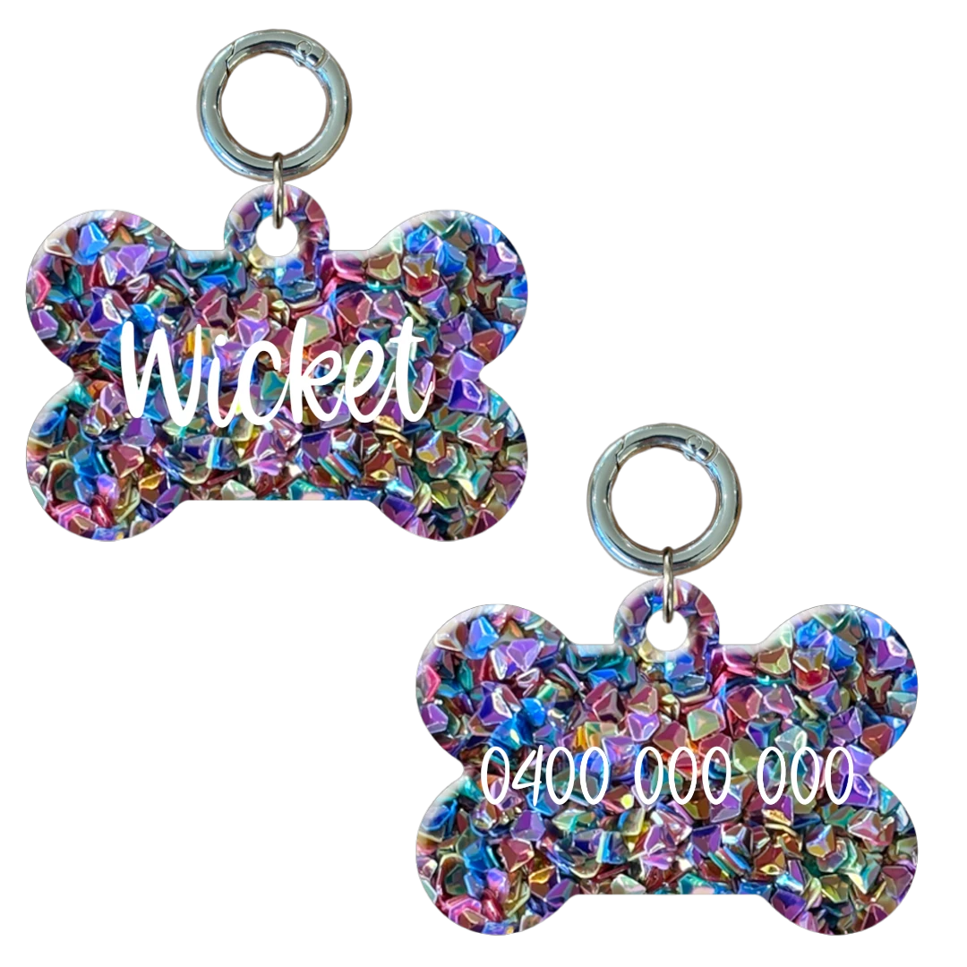 Colorful bone-shaped personalised dog tag with glitter, engraved with name and phone number.