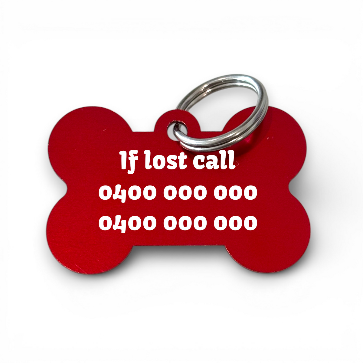 Red aluminium bone-shaped dog tag with engraved contact numbers and keyring.