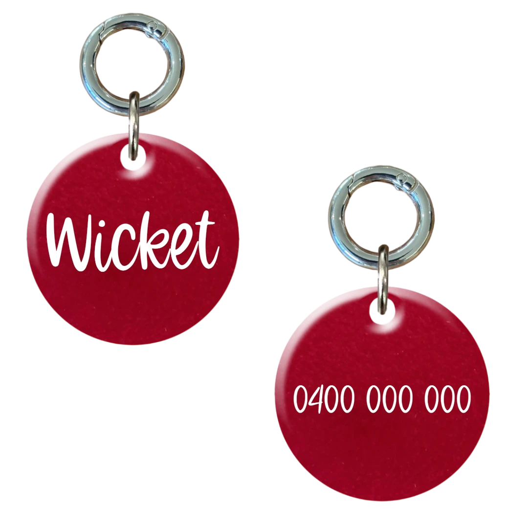 Red round personalised dog tag with metal ring, custom engraved with pet name and phone number.