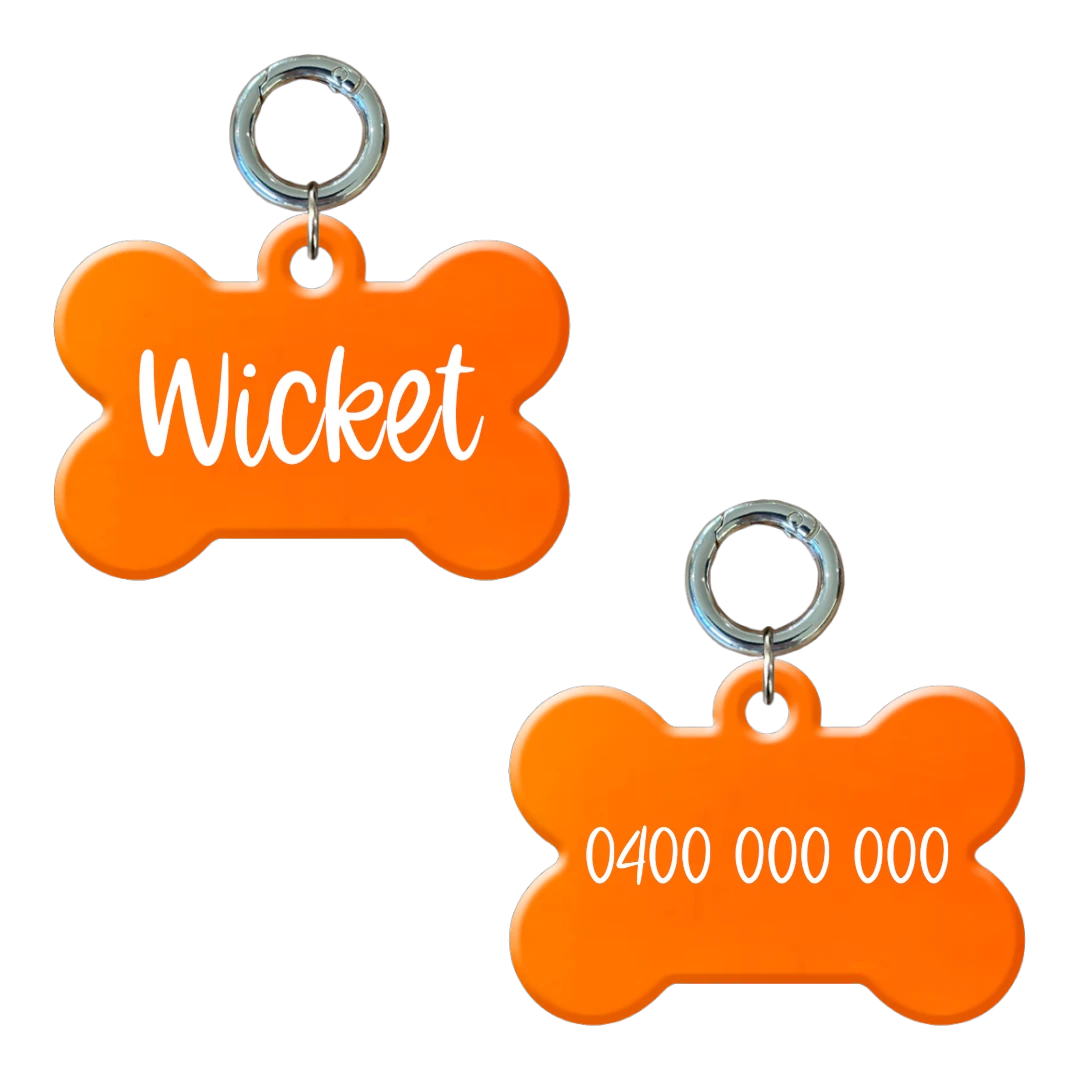 Personalised flourescent orange bone-shaped dog tag with name and phone number.