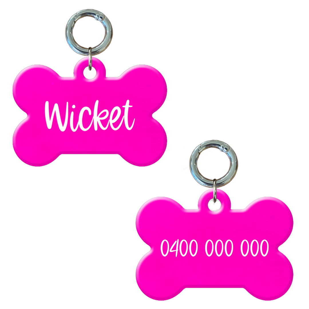 Personalised flourescent pink bone-shaped dog tag with name and phone number.
