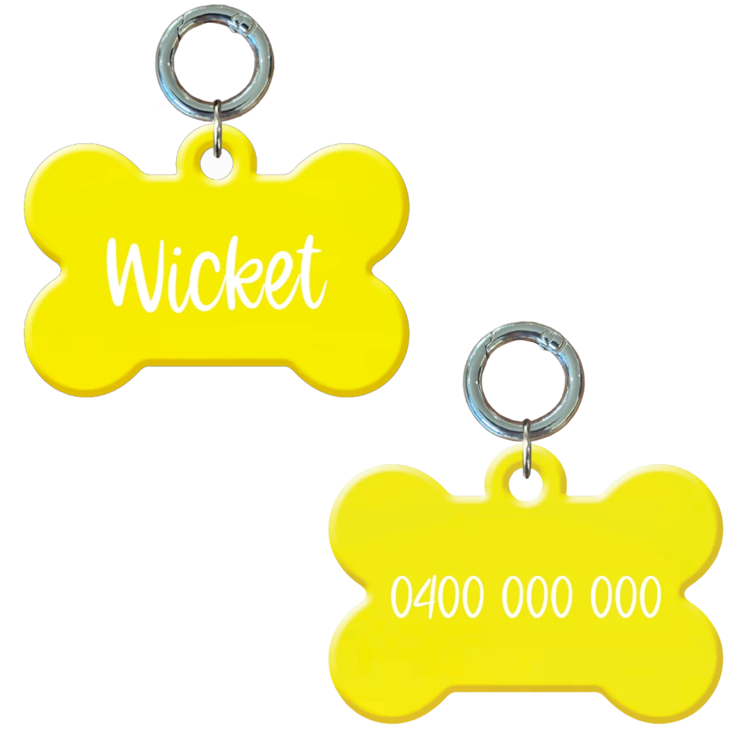 Personalised flourescent yellow bone-shaped dog tag with name and phone number.