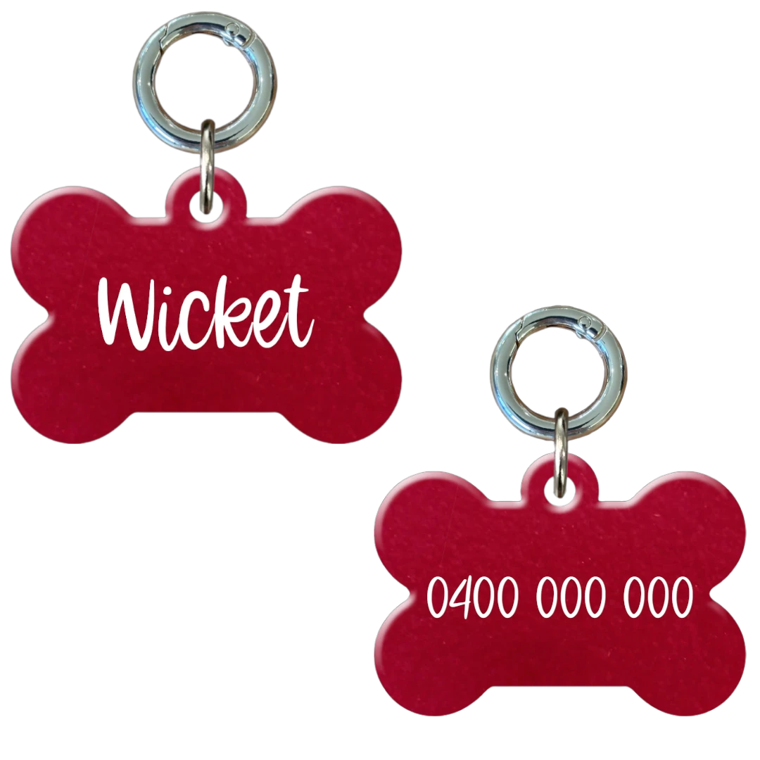 Red bone-shaped personalised dog tag with engraved name and phone number.